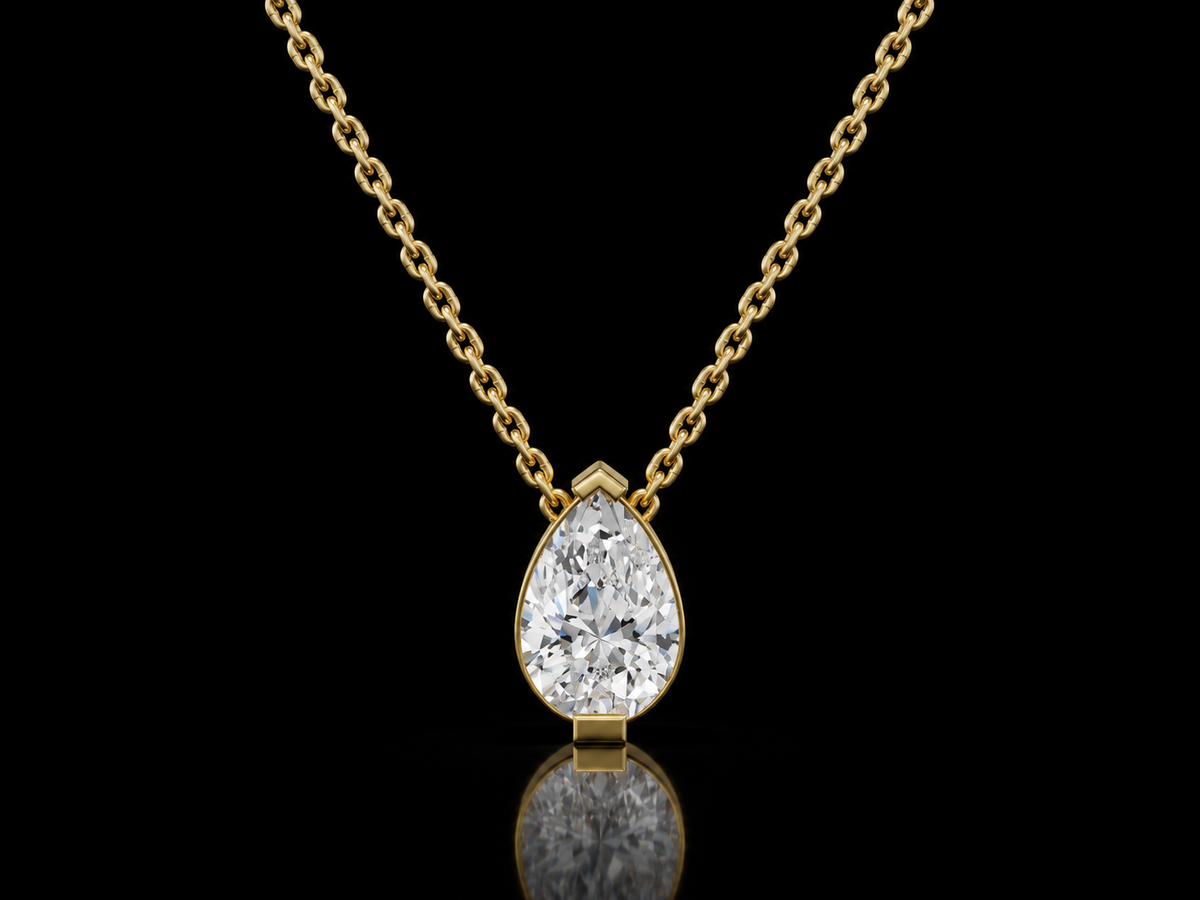 Pear-cut lab-grown diamond solitaire pendant necklace in yellow gold on black background