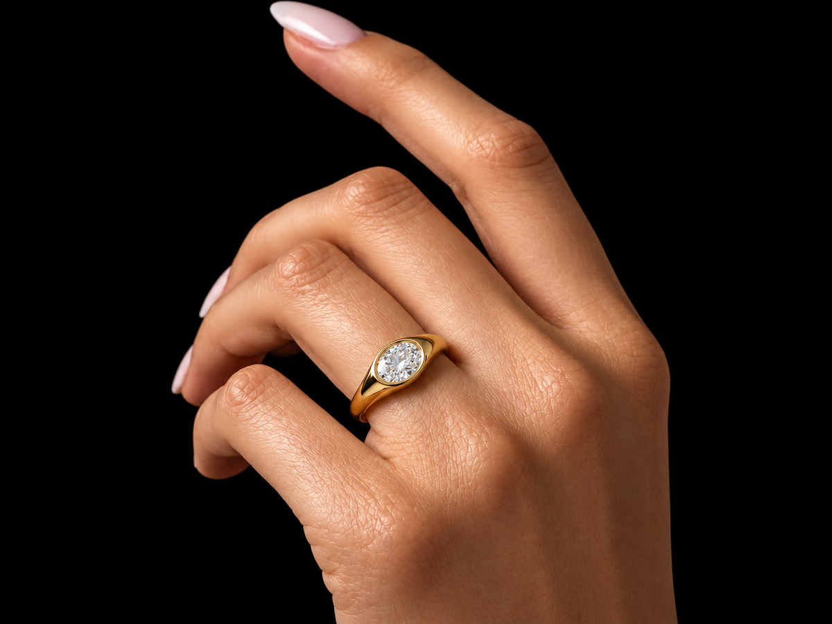 East-West oval diamond signet ring worn on hand